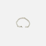 The TATEOSSIAN Bici Chain Bracelet is a luxury silver stainless steel accessory featuring a central rectangular plate. Shown partially unfastened on a white background, it highlights its polished links and clasp.