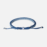 A blue and white Tateossian Evil Eye Macrame Bracelet featuring a central evil eye bead and adjustable silver-toned metal tips.