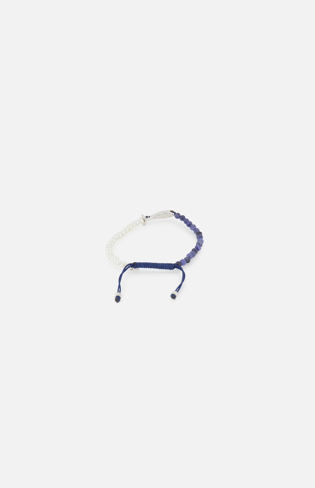 The TATEOSSIAN Feng Shui Fish Macrame Bracelet features half white and half navy blue beading, blue sodalite beads, and a navy blue sliding knot closure with two loose cord ends, shown on a plain white background.