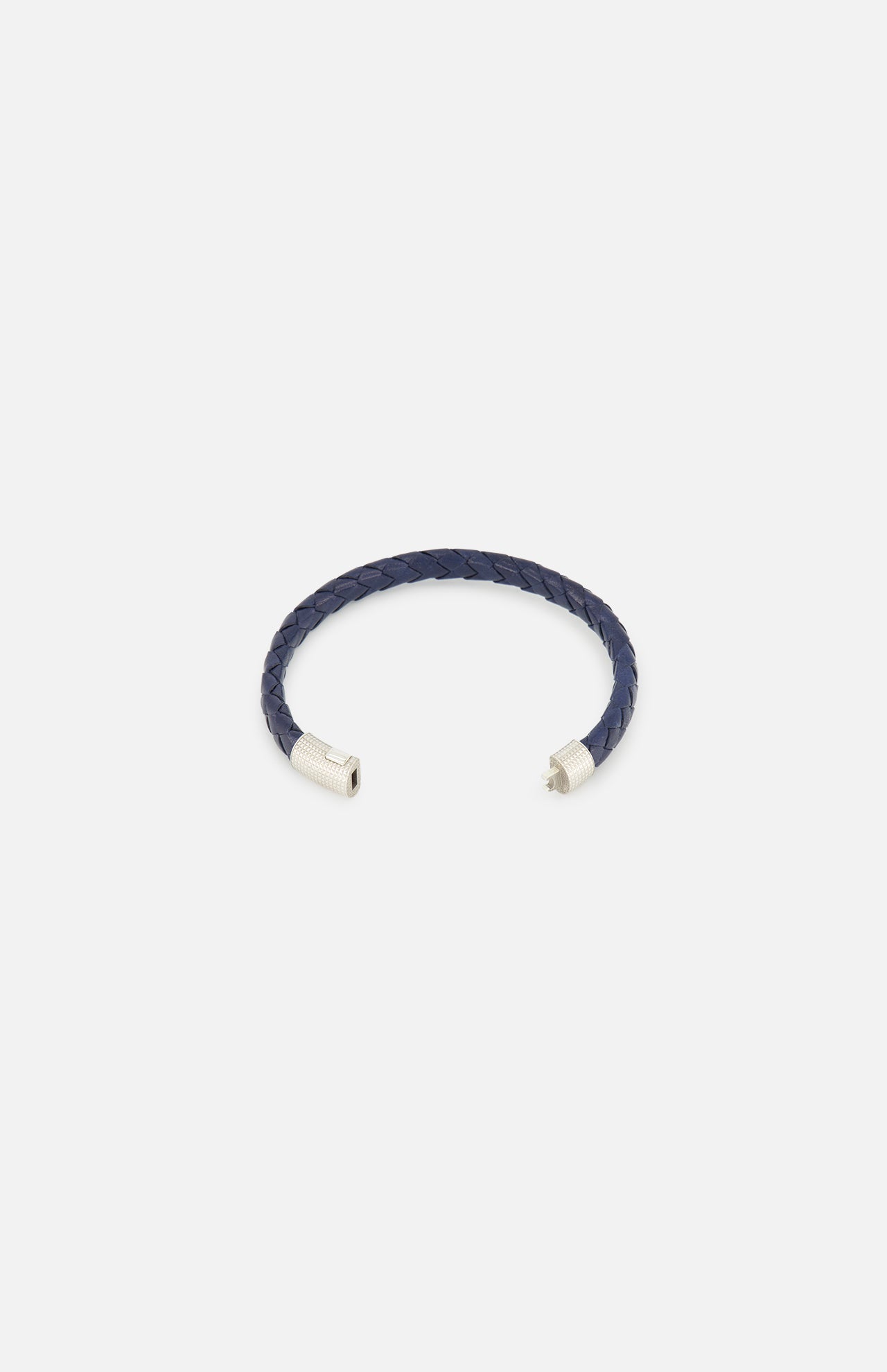 The TATEOSSIAN Giza Double Click Pelle Bracelet, featuring navy braided leather and sterling silver end caps in a stylish open-ended C-shape, is displayed on a plain white background.