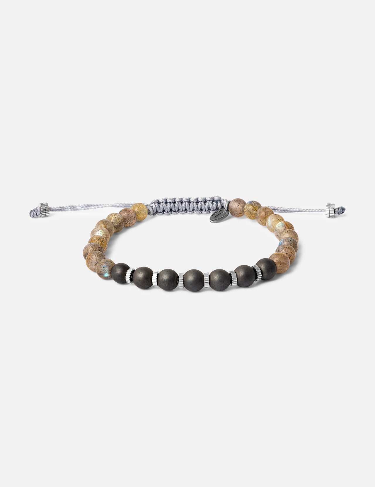 The TATEOSSIAN Titanium Macrame Bracelet features matte black, brown stone, and titanium beads with a braided gray cord and metallic accents, shown on a plain white background.