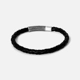 The Vintage Herringbone Click Bracelet by TATEOSSIAN features black braided leather and a stainless steel clasp, shown on a plain light gray background—a refined men's luxury accessory.