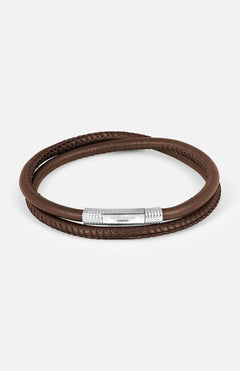 The TATEOSSIAN Rhodium & Leather Bracelet showcases a double-wrap brown leather band and a textured rhodium-plated clasp engraved with the brand logo, displayed on a white background.