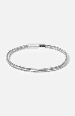 The TATEOSSIAN All-metal Design Bracelet showcases a minimalist rhodium-plated silver braided chain with a cylindrical clasp, elegantly displayed on a plain white background.