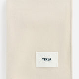Off-white TEKLA Lambswool Blanket with a stitched label in the corner.