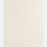 A rectangular off-white TEKLA Lambswool Blanket with a small white brand label in the bottom right corner.