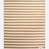 Rectangular TEKLA Striped Lambswool Blanket featuring horizontal tan and cream stripes with a small logo tag in the bottom corner.