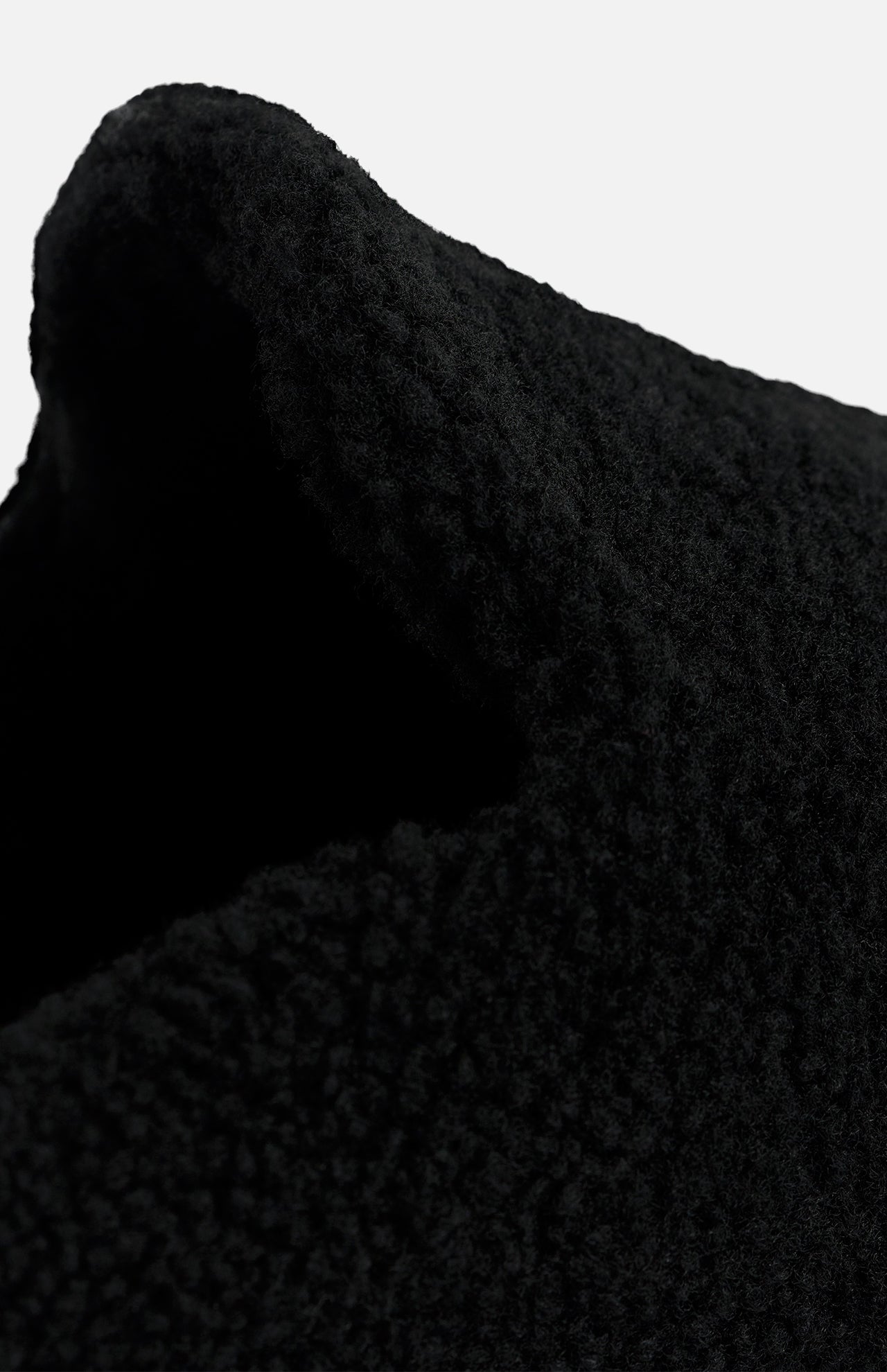 Close-up of a black textured TEKLA Shearling Slipper with a cushioned footbed.
