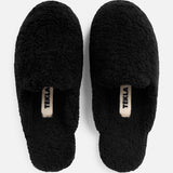 Pair of black TEKLA Shearling Slippers with logo tags on the cushioned footbeds.