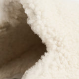 Close-up of the opening of a cream-colored TEKLA Shearling Slipper with a cushioned footbed.