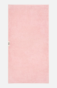 A light pink TEKLA Terry Bath Towel in organic cotton with a small branded label on the left edge.