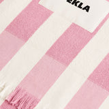 Pink and white striped fringed TEKLA Terry Beach Towel with a white logo patch.