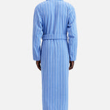 A person seen from the back wearing a blue, white-striped, tie-waist Terry Classic Unisex Bathrobe by TEKLA.