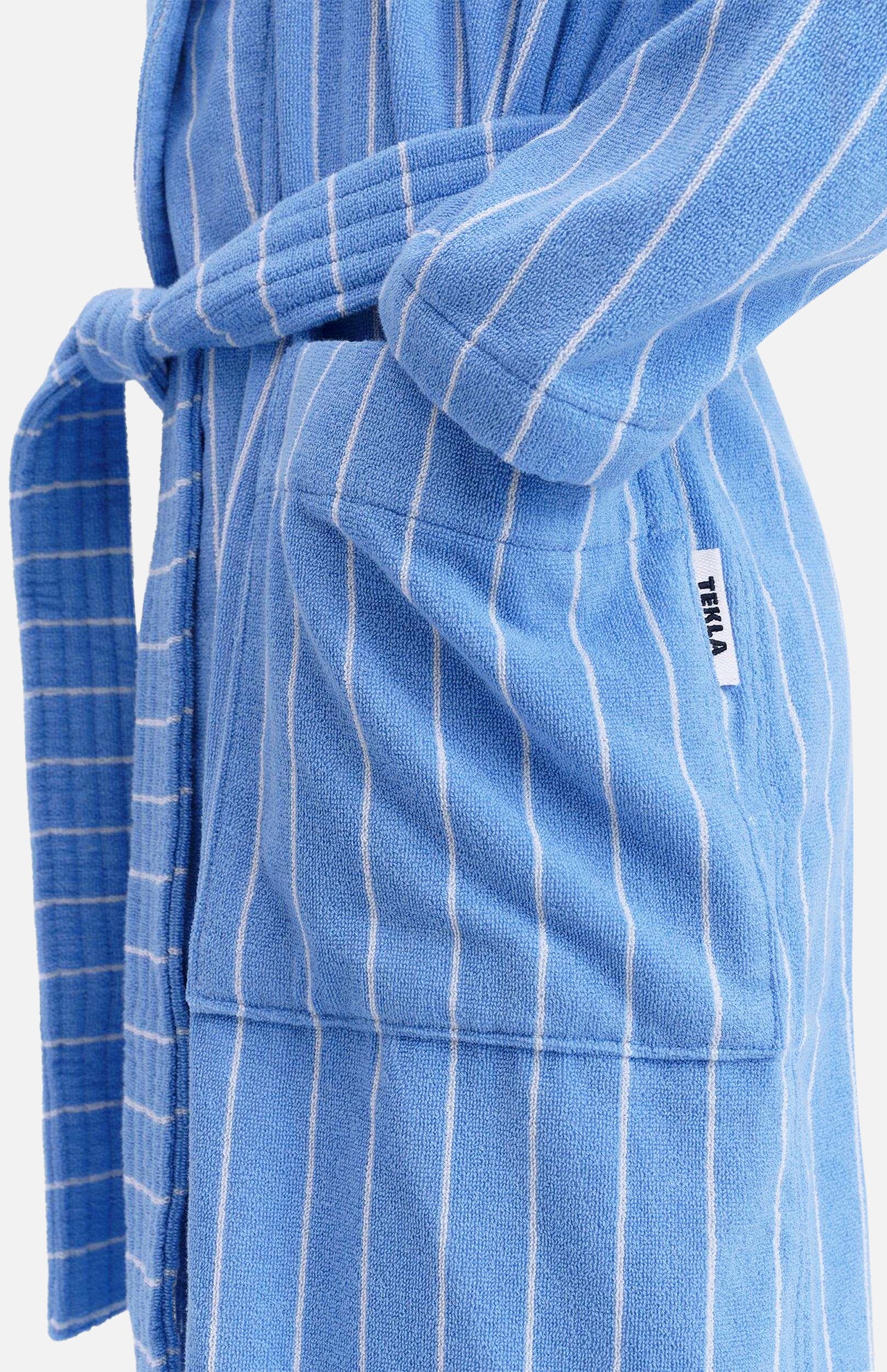 TEKLA Terry Classic Unisex Bathrobe in blue and white stripes, featuring a tie belt and a front pocket with a logo tag.