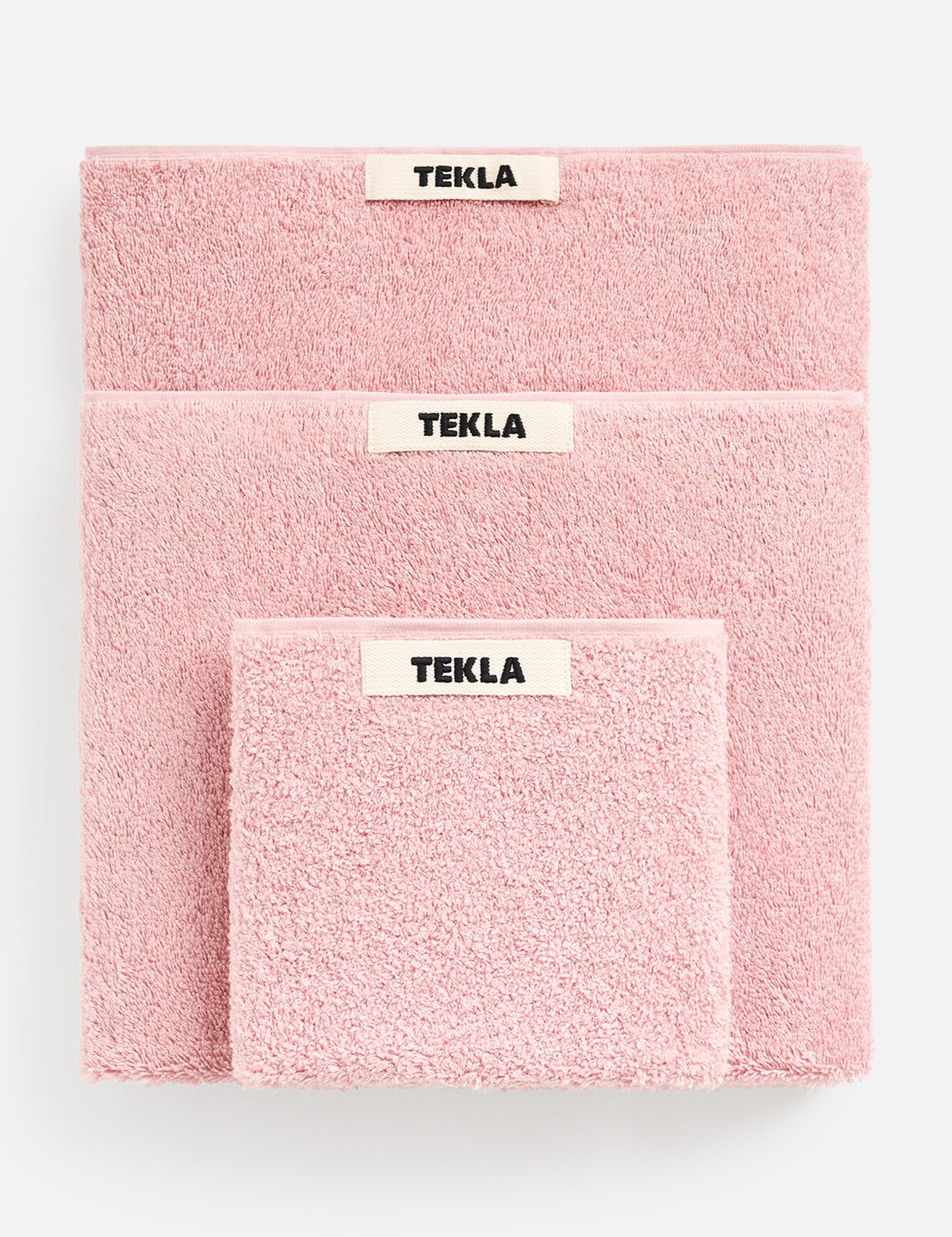 Three soft Terry Towel Washcloth sets in descending sizes, each featuring a centered TEKLA brand label and a matching pink washcloth.