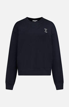 The RAG & BONE That's the Spirit Sweatshirt is a black cotton-blend, long-sleeve top featuring small white "Whats our story?" text on the upper left chest, shown against a white background.