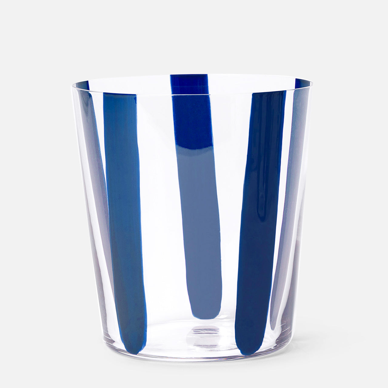 The Nova Stripe Tumbler Set of 4 by THE CONRAN SHOP features clear crystal glasses with evenly spaced vertical blue brushstroke stripes, reminiscent of hand-painted designs, set against a light gray background.