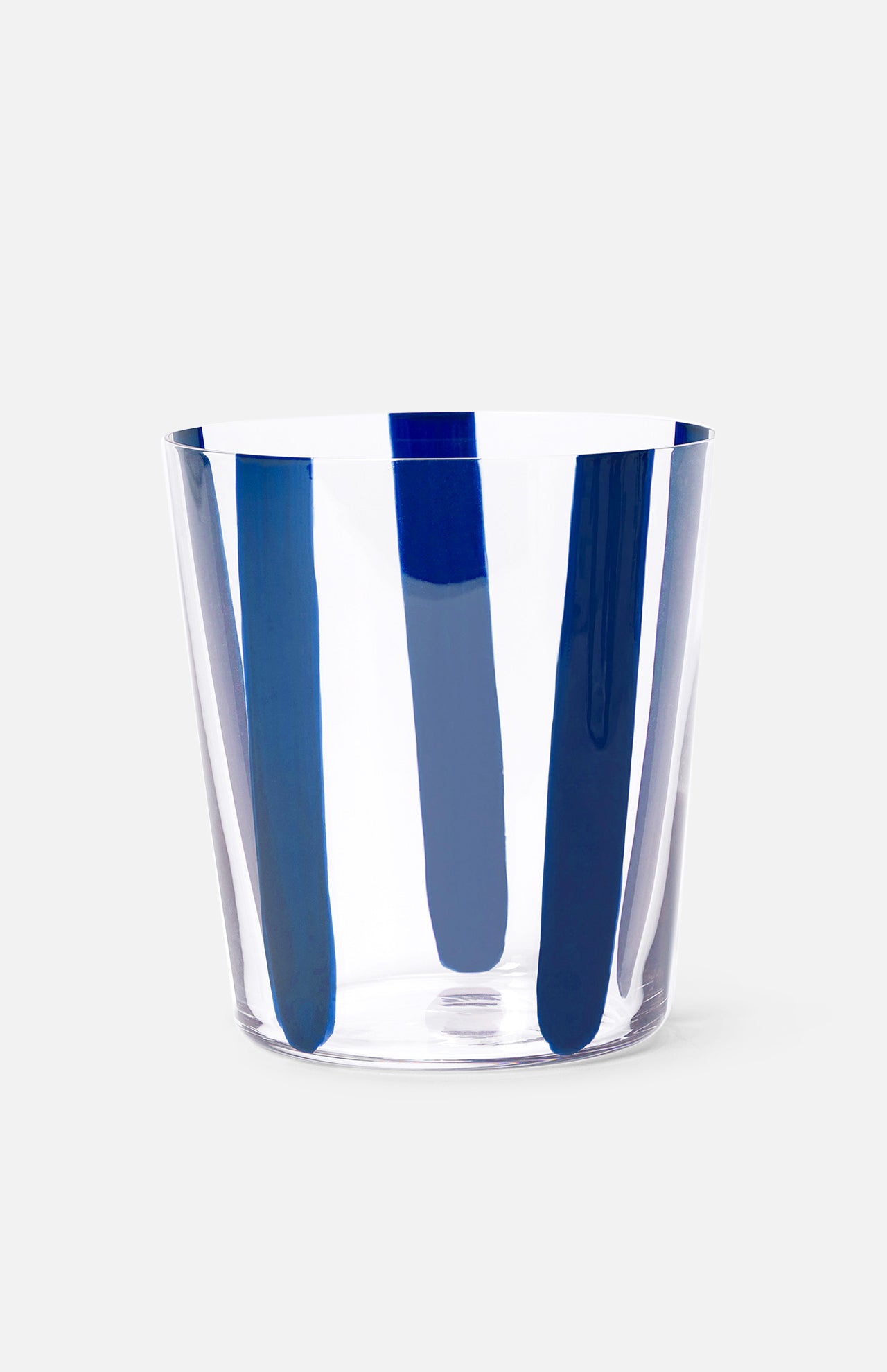 The Nova Stripe Tumbler Set of 4 by THE CONRAN SHOP features clear crystal glasses with evenly spaced vertical blue brushstroke stripes, reminiscent of hand-painted designs, set against a light gray background.