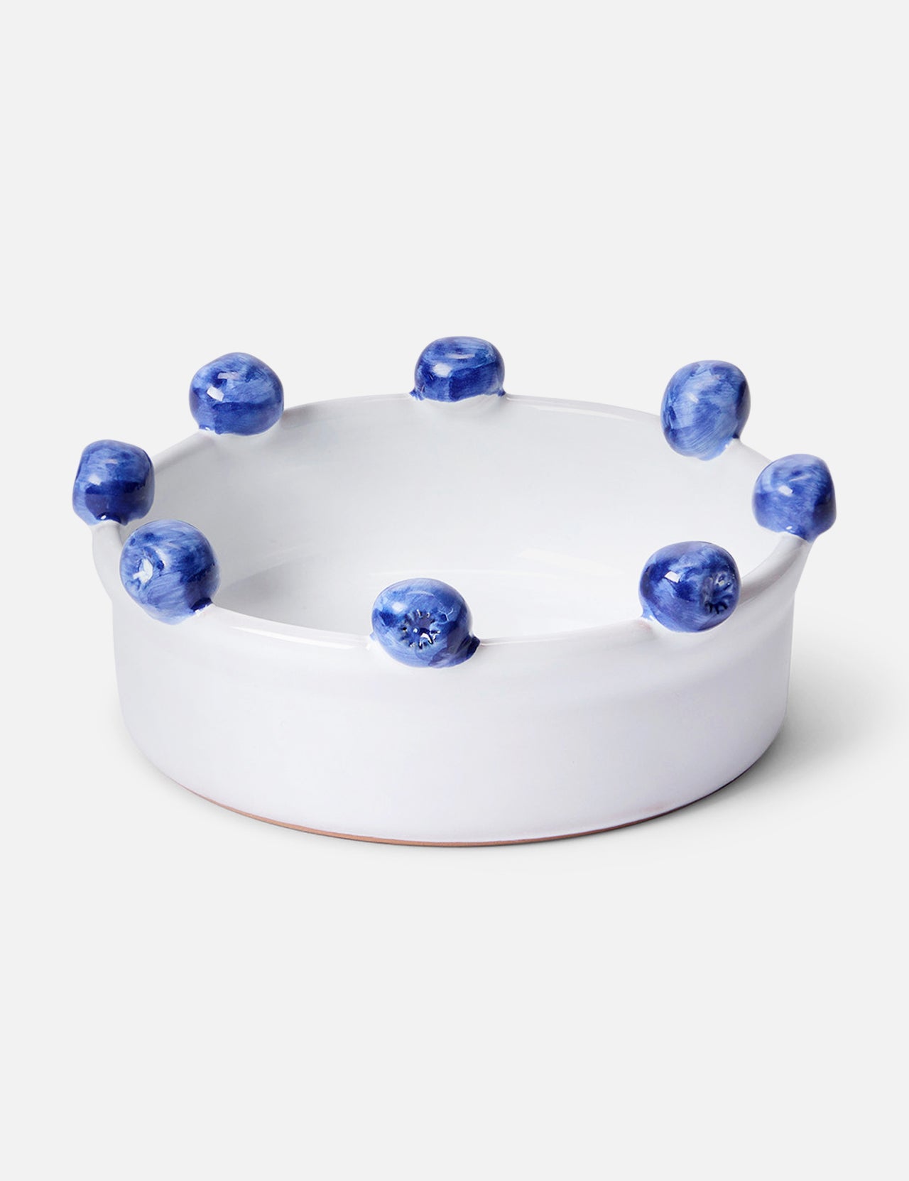 The Puglia Blueberry Serving Bowl by THE CONRAN SHOP is a round white ceramic bowl, handcrafted in Italy, featuring blue textured knobs evenly spaced around the rim and shown against a light background.