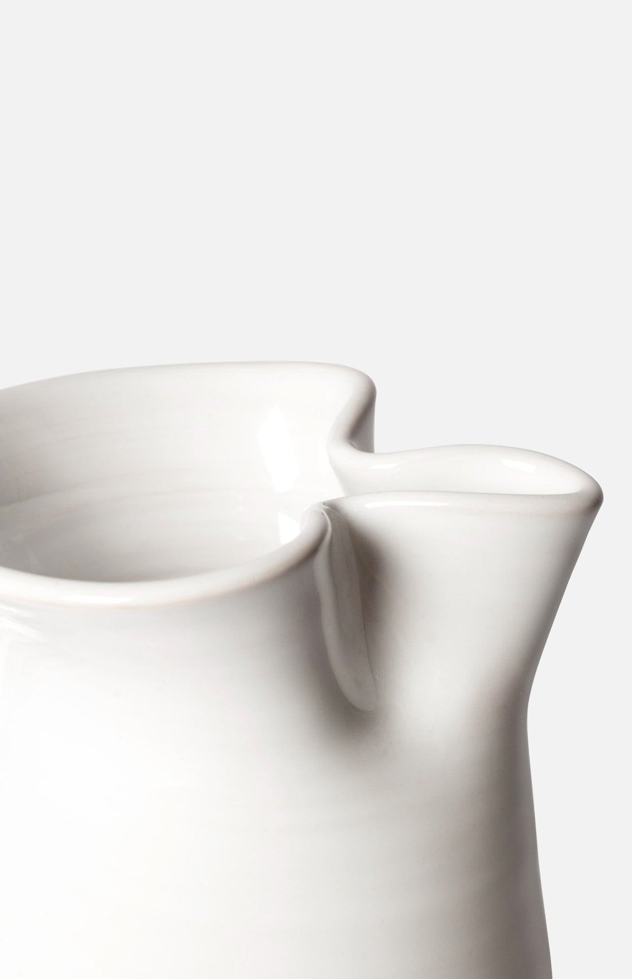 Close-up of the Puglia Jug with Plaited Handle by THE CONRAN SHOP, featuring a smooth white stoneware finish and elegantly curved spout, highlighting refined Italian craftsmanship against a plain light background.