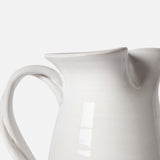 A close-up of THE CONRAN SHOP's Puglia Jug with Plaited Handle, featuring a white stoneware body, handle, and spout, set against a plain background—an elegant handcrafted ceramic piece from Italy.