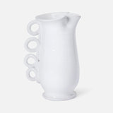 The Puglia Jug with Ring Handle by THE CONRAN SHOP is a white ceramic pitcher inspired by Puglia ceramics, featuring a curved body and four ring handles stacked vertically on one side.