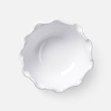 The Puglia Scalloped Small Bowl by THE CONRAN SHOP is a white stoneware piece with a glossy finish and wavy edges, shown from above on a light gray background. Handcrafted in Italy, it offers timeless elegance.