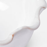Close-up of the rim of THE CONRAN SHOP's Puglia Scalloped Small Bowl, a white stoneware piece with scalloped edges and subtle brown accents that highlight its handcrafted Italian artistry.