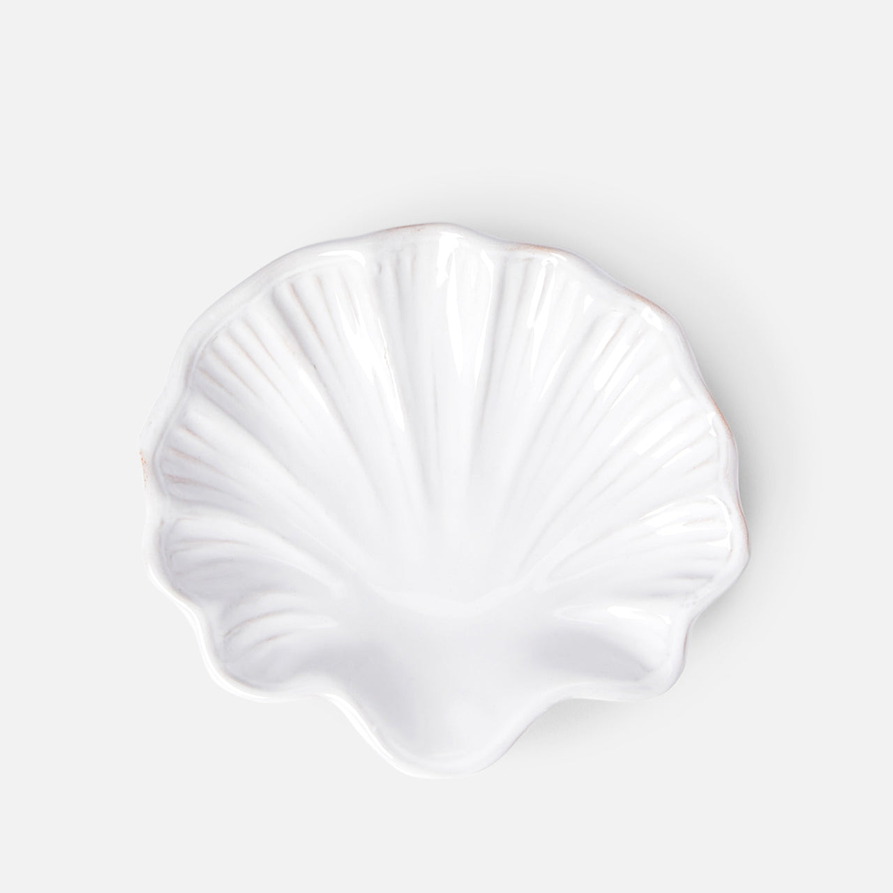 The Puglia Stoneware Shell Dish by THE CONRAN SHOP, shaped like a seashell, brings elegant coastal charm to any space with its handcrafted Italian ceramic design and light gray background.
