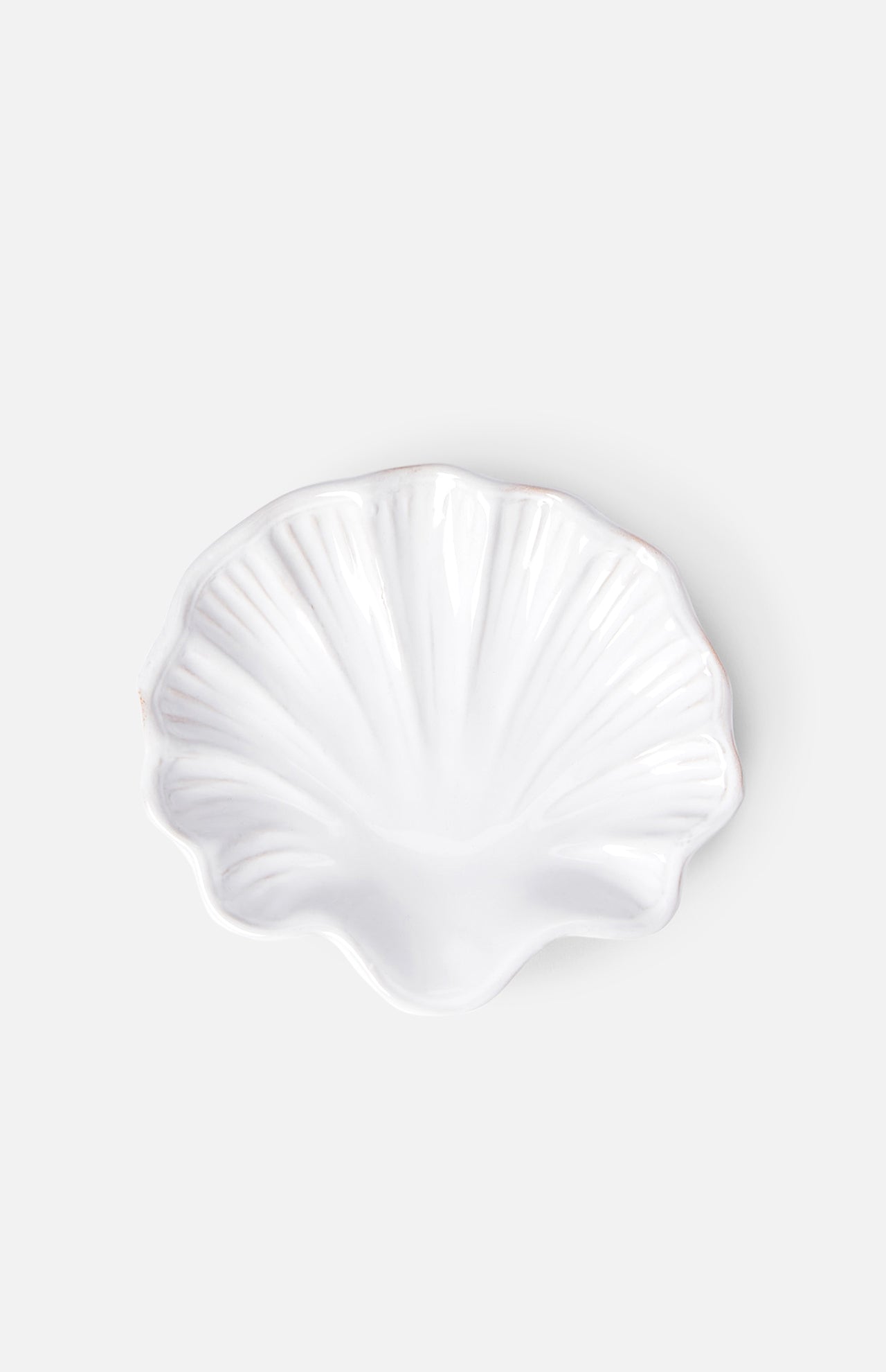 The Puglia Stoneware Shell Dish by THE CONRAN SHOP, shaped like a seashell, brings elegant coastal charm to any space with its handcrafted Italian ceramic design and light gray background.