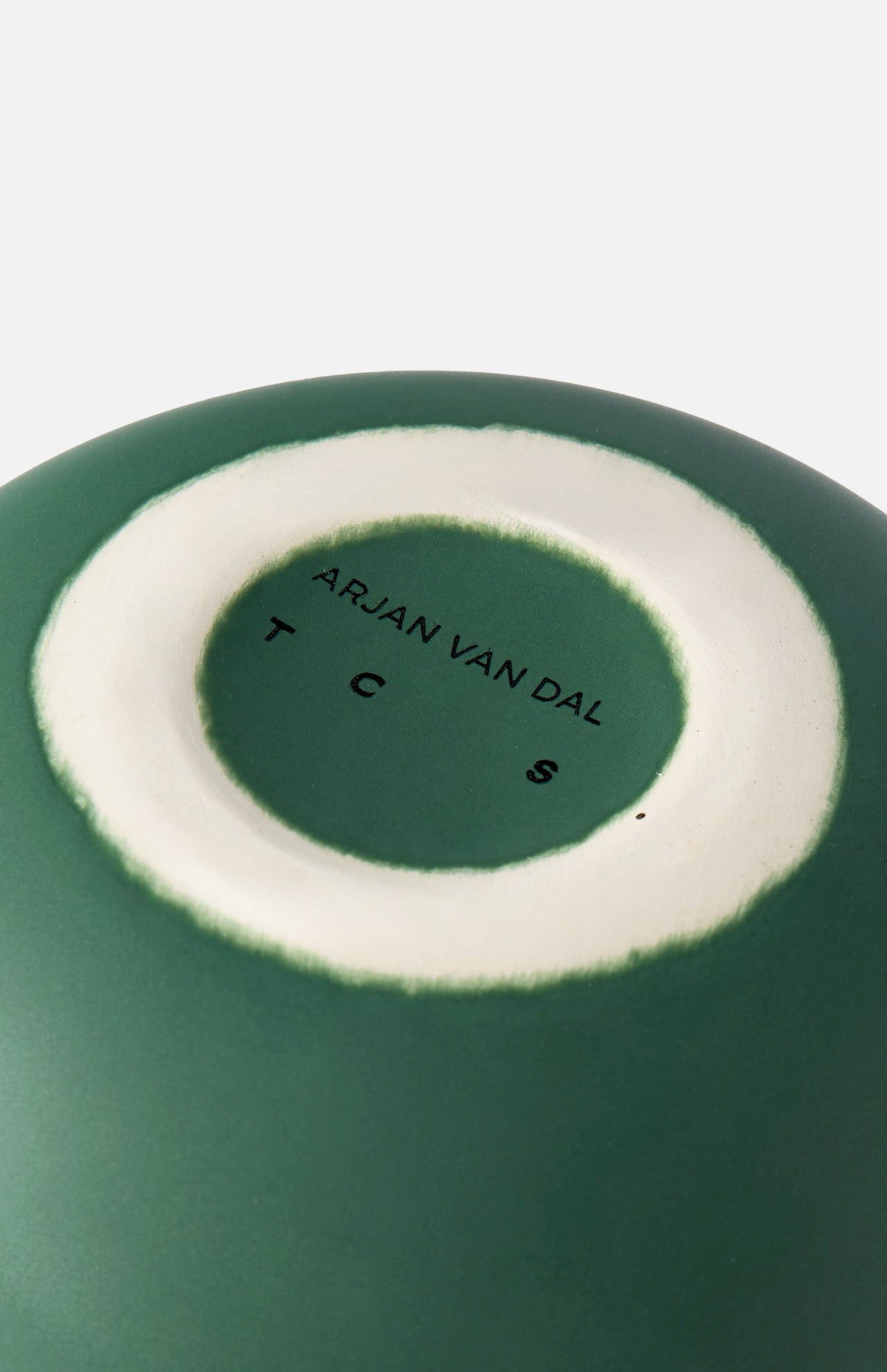 A close-up of the base of THE CONRAN SHOP Sphere Bottle Vase in forest green shows a white circular ring and ARJAN VAN DAL T C S stamped at the center.