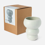 A mint, sculptural earthenware Stacked Spheres Vase by THE CONRAN SHOP with rounded, stacked bulb shapes sits beside its brown box, featuring an image and description on a white background.