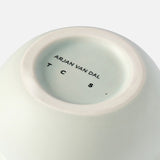 Close-up of the bottom of a white ceramic Stacked Spheres Vase Mint by THE CONRAN SHOP, with branding printed in black on the base, mirroring the signature style found on similar pieces.
