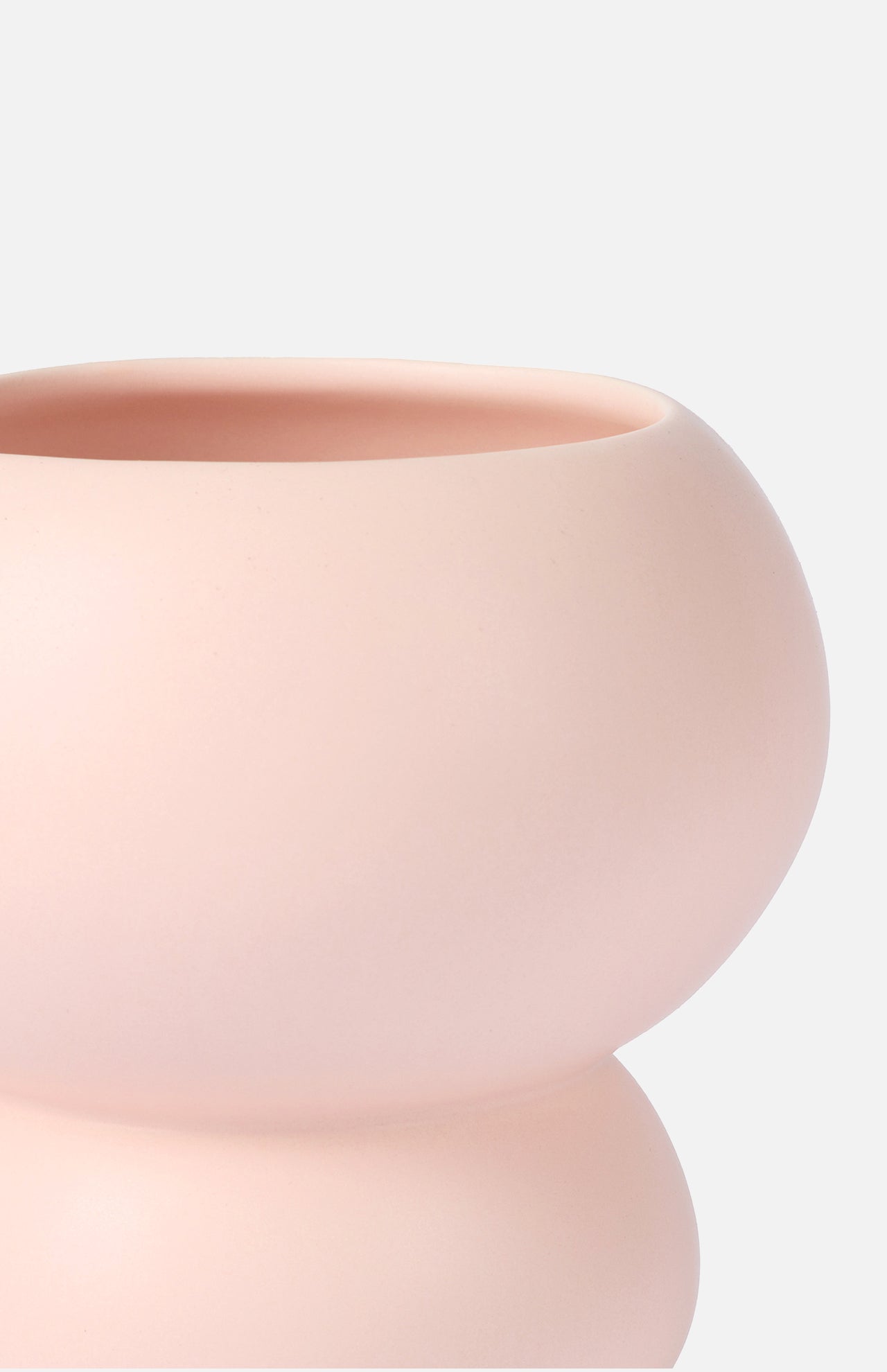 Close-up of THE CONRAN SHOP's Stacked Spheres Vase Plaster, a smooth, round earthenware vase in pale pink with a wide opening and soft matte finish, set against a plain light background.