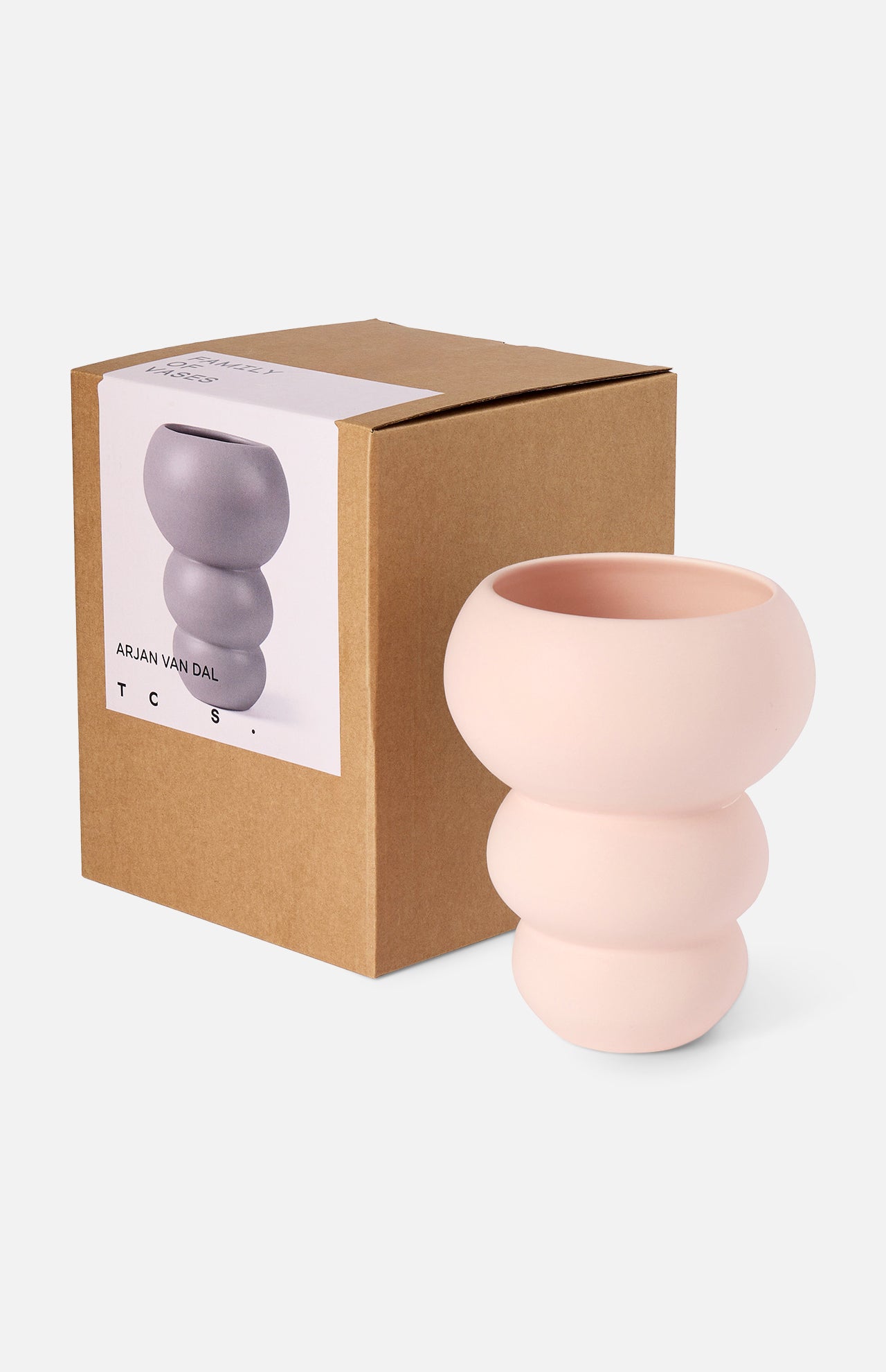 A sculptural, pale pink Stacked Spheres Vase Plaster by THE CONRAN SHOP with rounded, bubble-like shapes sits beside its brown box, which features an image and description of the vase on a white label.