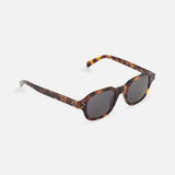 The CELINE Round Brown Tortoiseshell Sunglasses feature oval dark lenses, thick frames, and gold hinge details, channeling classic French luxury style on a white background.