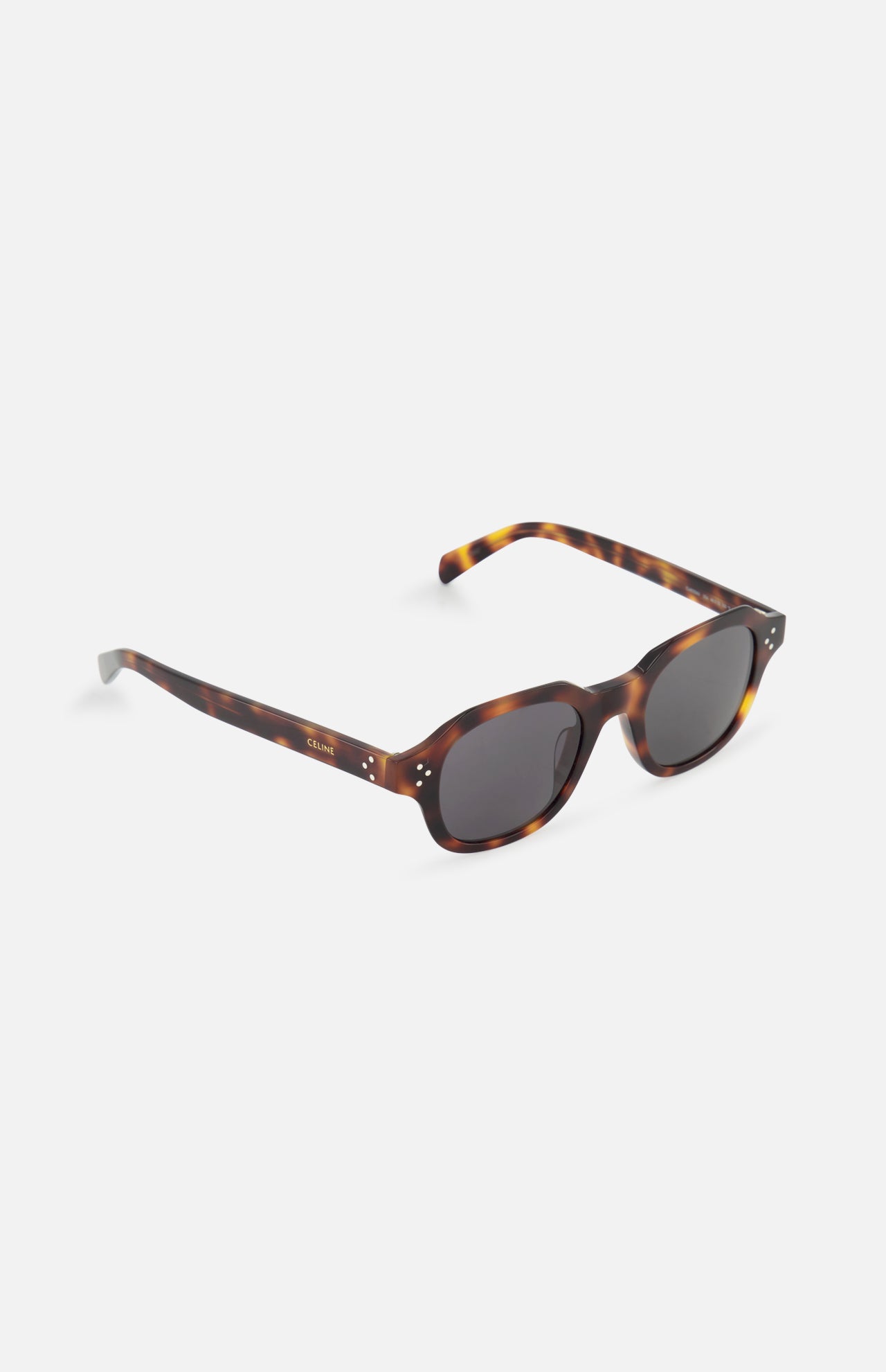 The CELINE Round Brown Tortoiseshell Sunglasses feature oval dark lenses, thick frames, and gold hinge details, channeling classic French luxury style on a white background.