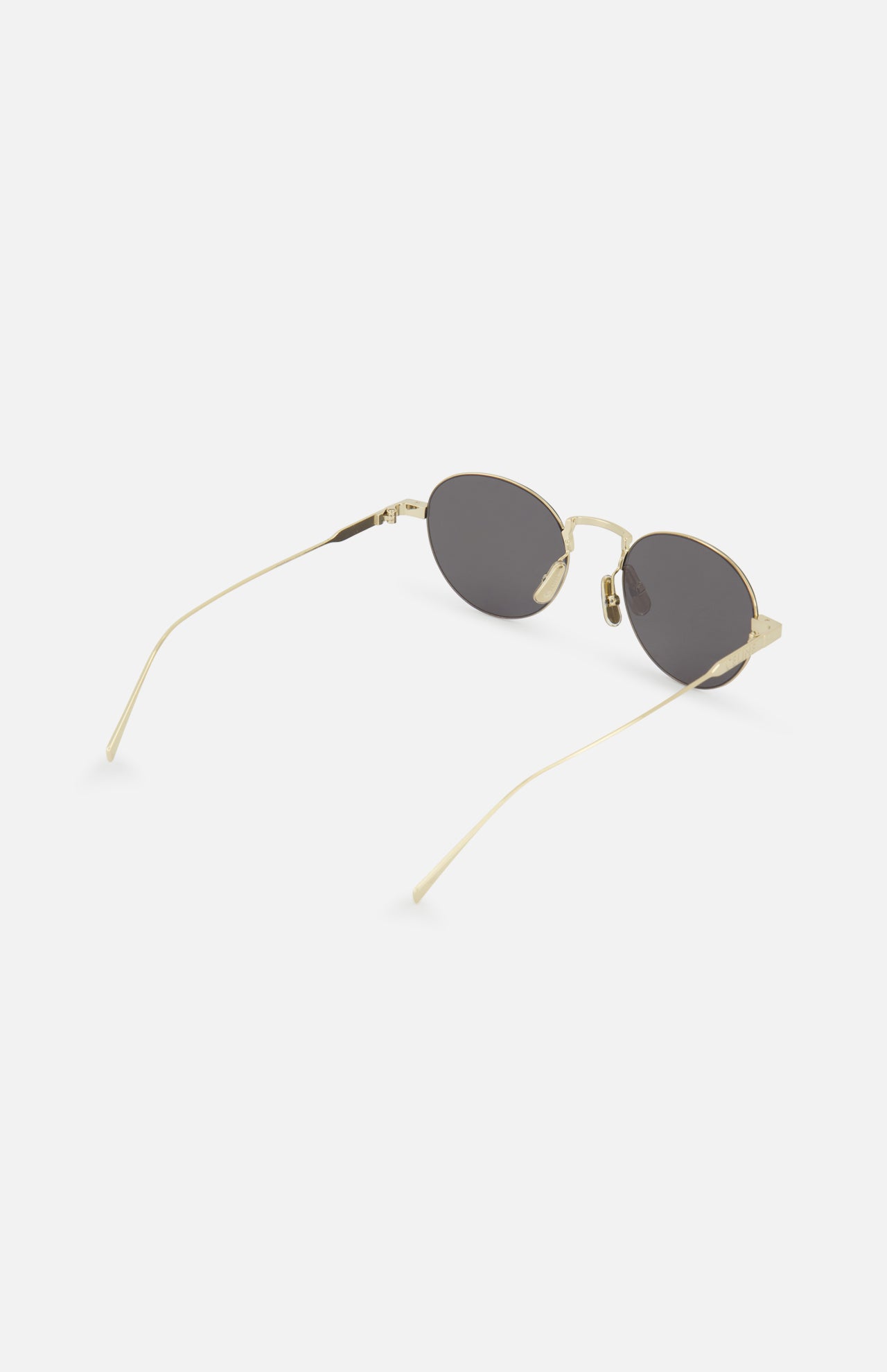 CELINE Round Gold Sunglasses feature gold frames, dark lenses, thin metal arms, and adjustable nose pads, capturing timeless French elegance on a white background.