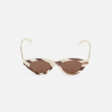 The CELINE Round Animal Print Sunglasses feature a cat-eye silhouette with cream and brown tortoiseshell frames and brown tinted lenses, crafted in Italy and showcased against a white background.