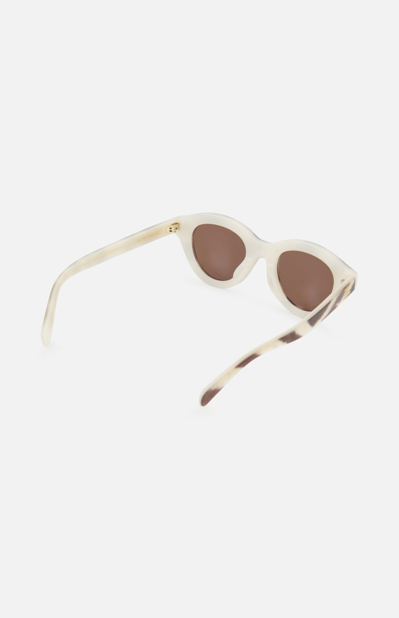 Celine Round Animal Print Sunglasses by CELINE, featuring a beige cat-eye frame with brown lenses and made in Italy, are displayed at an angle to showcase the front and one side against a plain white background.