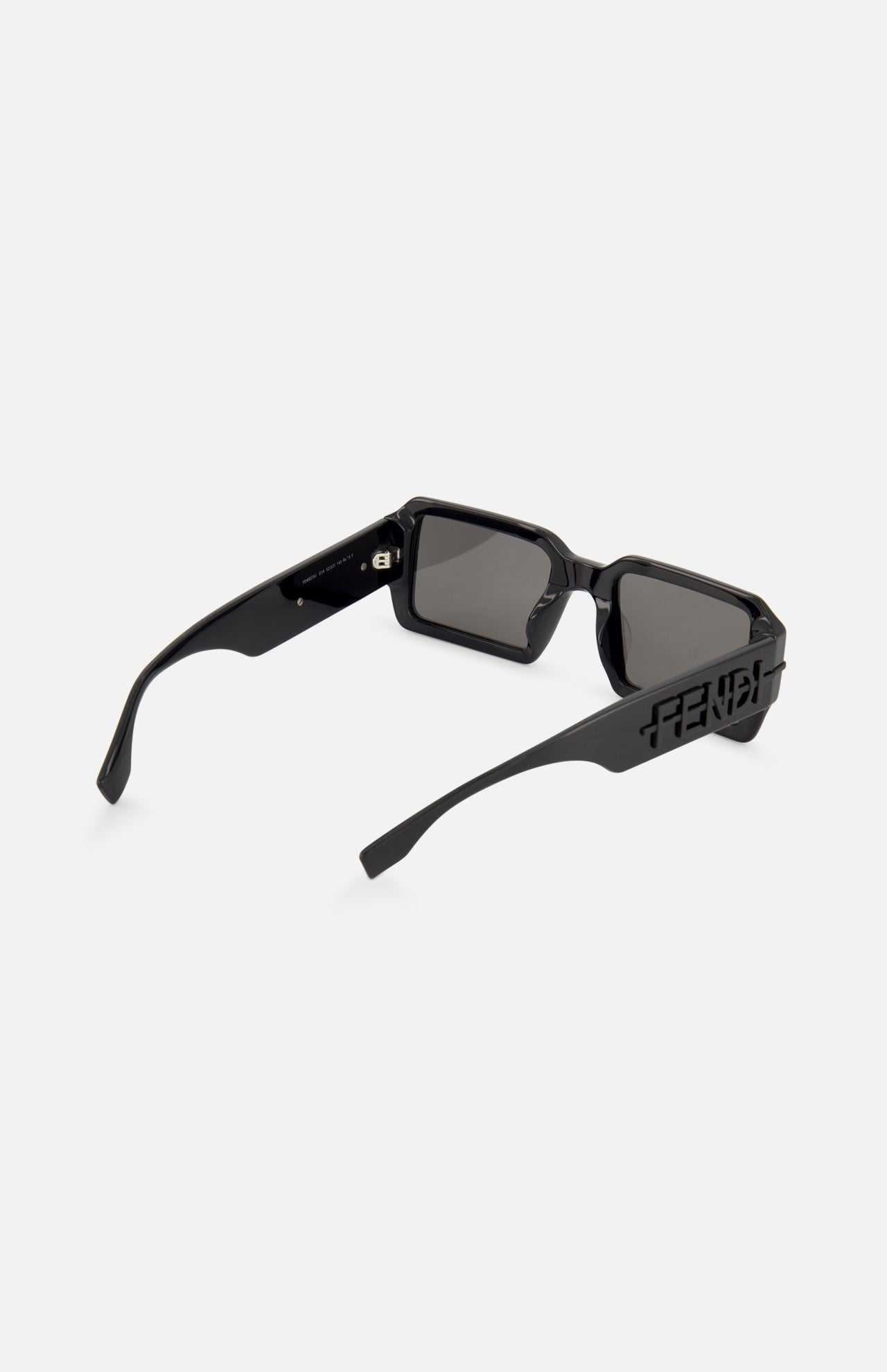 The FENDI Rectangular Black Sunglasses feature thick arms, tinted lenses, and a cut-out Fendi logo on the temples. These statement sunglasses are displayed on a plain white background.