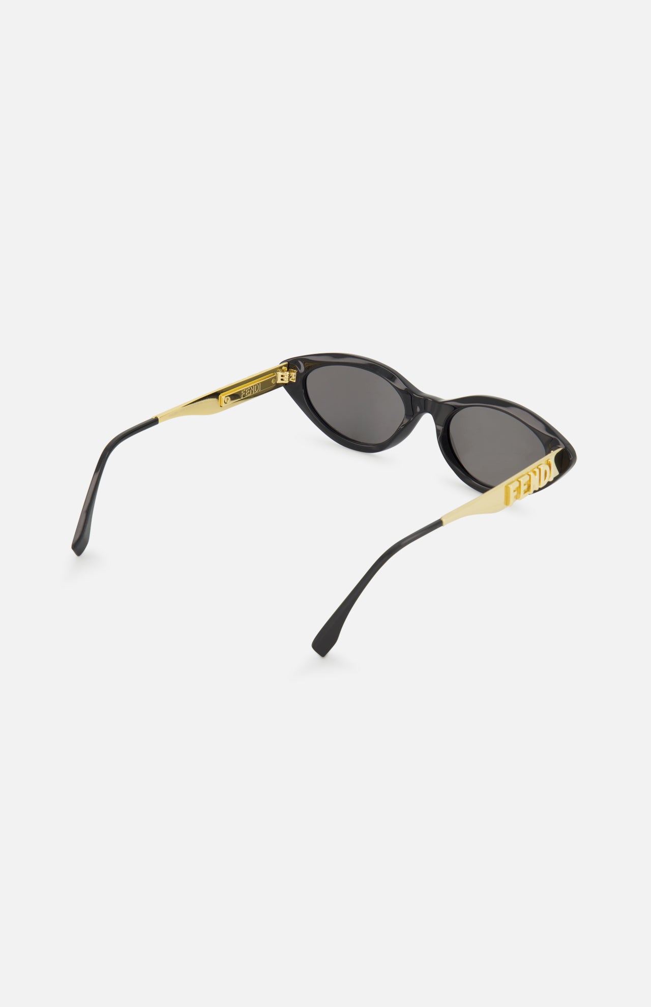 Fendi Cat Eye Black Sunglasses by FENDI feature gold arms, the iconic logo on the sides, a sleek modern design, and dark lenses for a chic look.