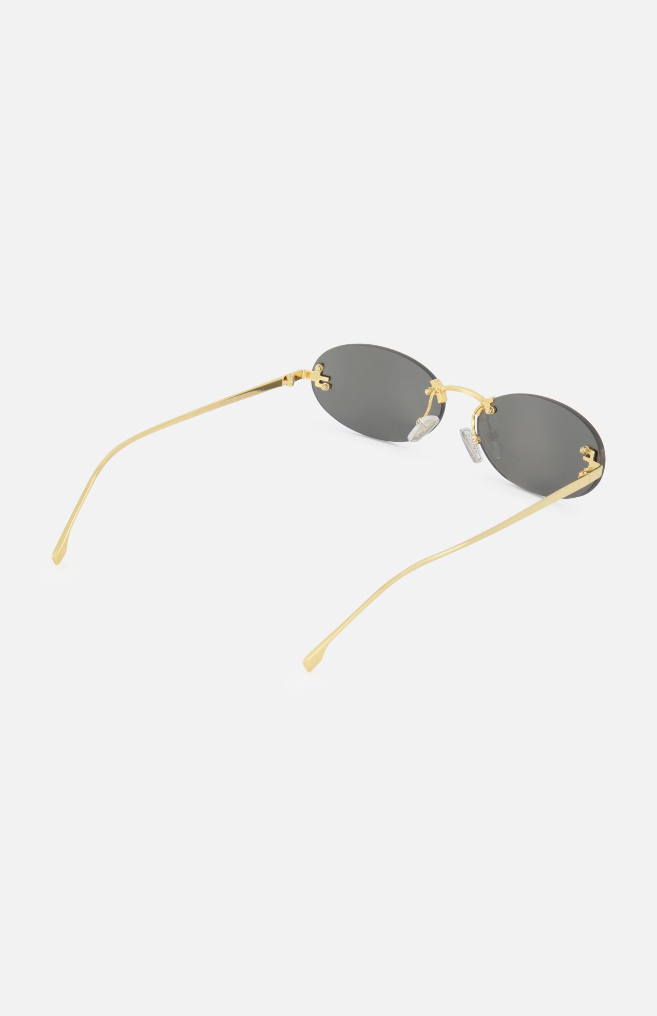 The Fendi Oval Gold Sunglasses by FENDI showcase an elegant oval frame with thin gold metal accents and dark lenses, presented against a white background.
