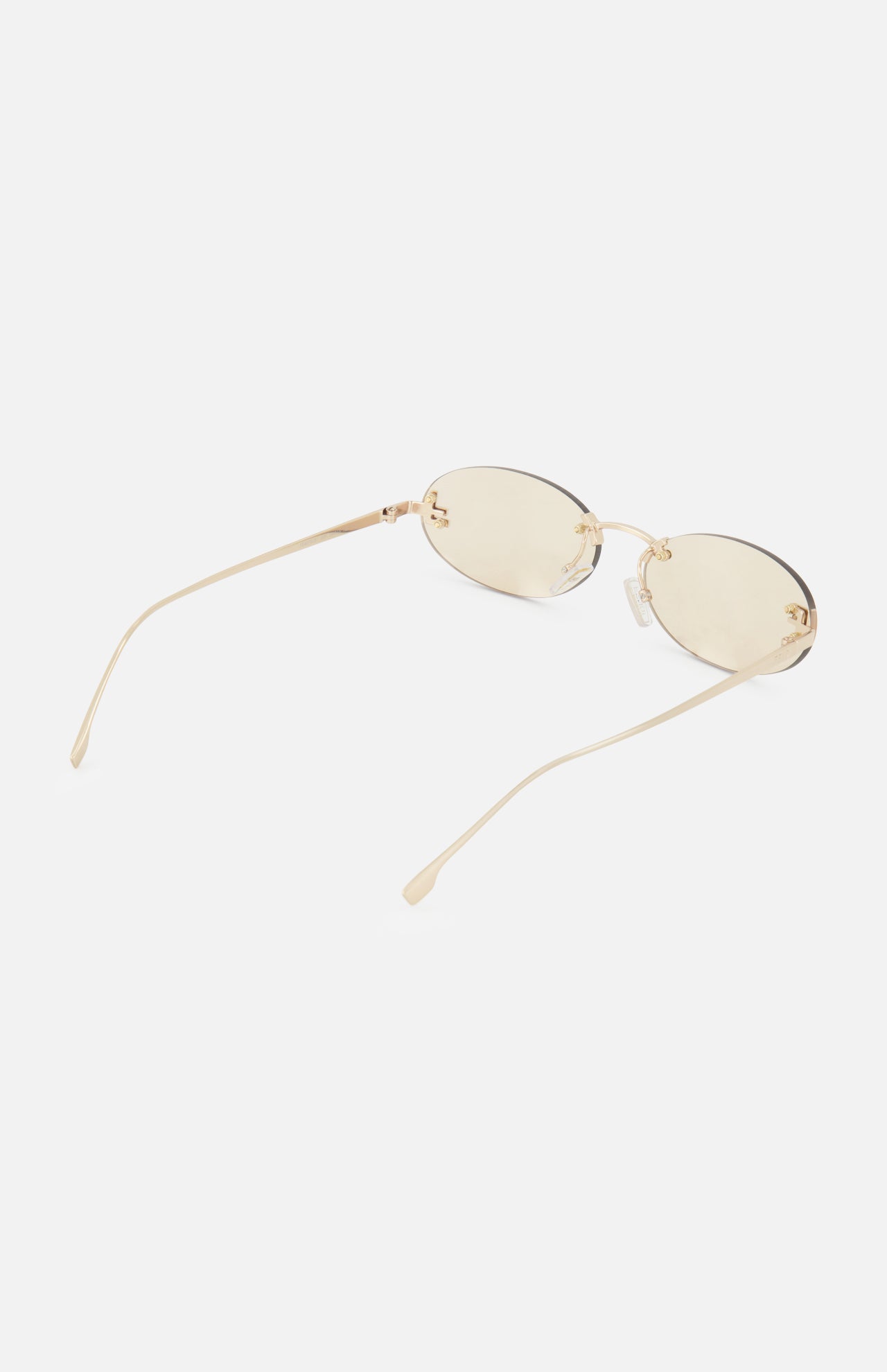 The Fendi Oval Rose Gold Sunglasses by FENDI feature oval frames with light gold-tinted lenses and slender rose gold metal arms, showcased against a white background.