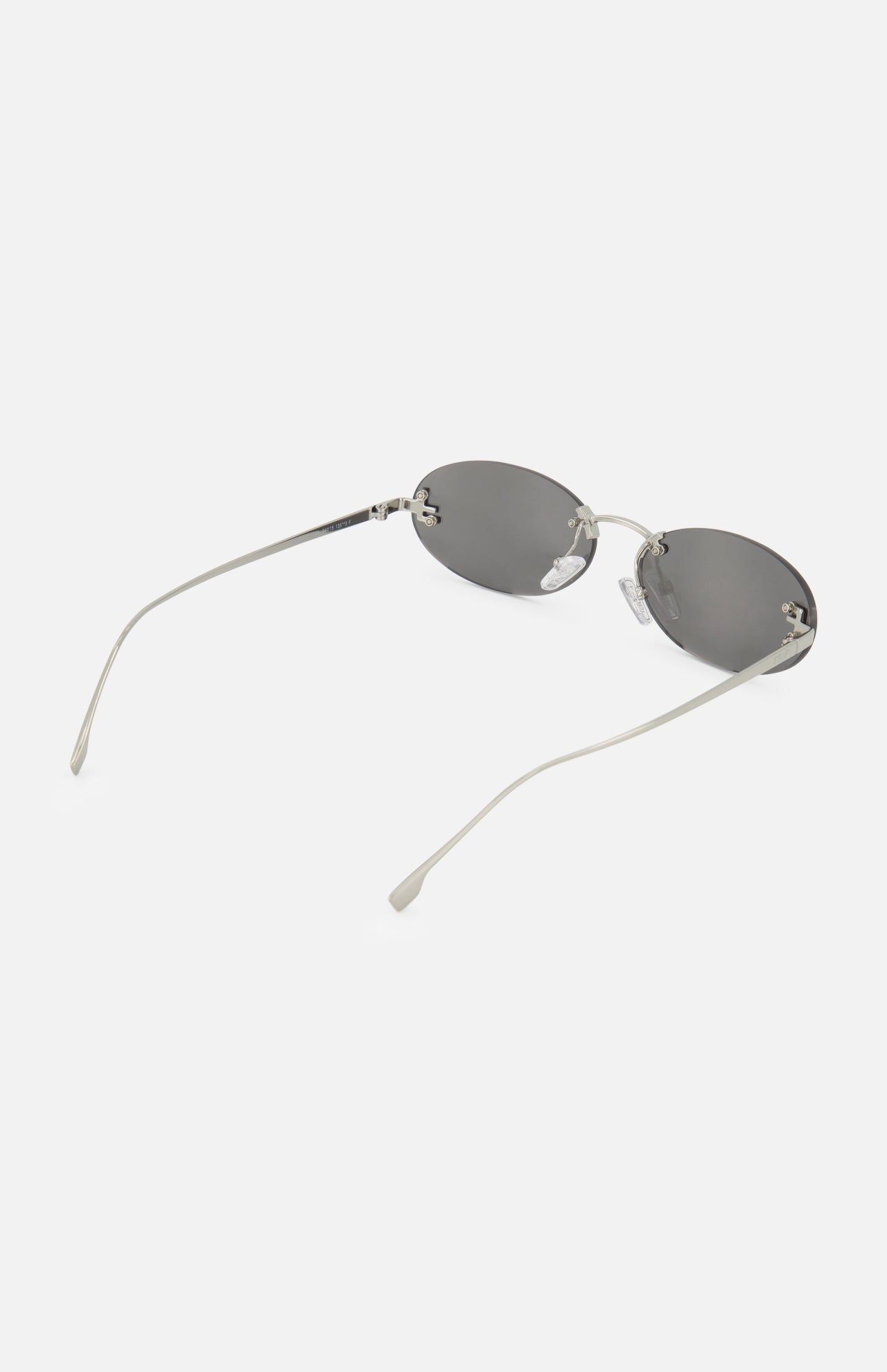 FENDI Oval Silver Sunglasses with thin silver metal frames and dark lenses, displayed on a white background. These designer sunglasses by Fendi feature slightly curved arms that extend backward, combining timeless style with modern sophistication.