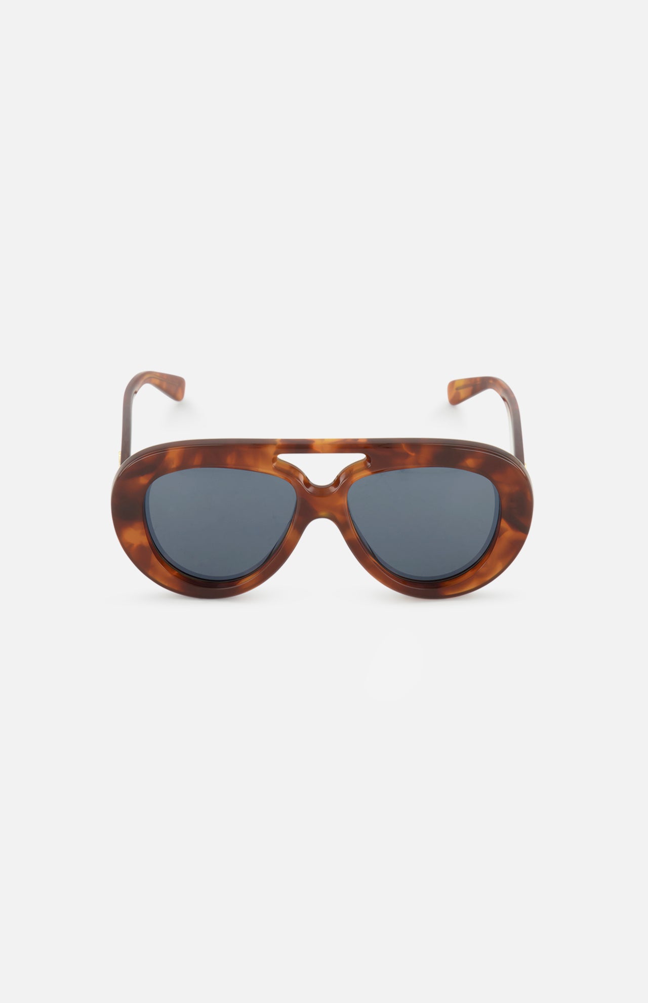 The LOEWE Aviator Brown Tortoiseshell Sunglasses are displayed against a plain white background. These sunglasses by LOEWE feature thick, oval frames in a brown tortoiseshell pattern with dark lenses and a keyhole bridge, combining timeless style with modern design elements.