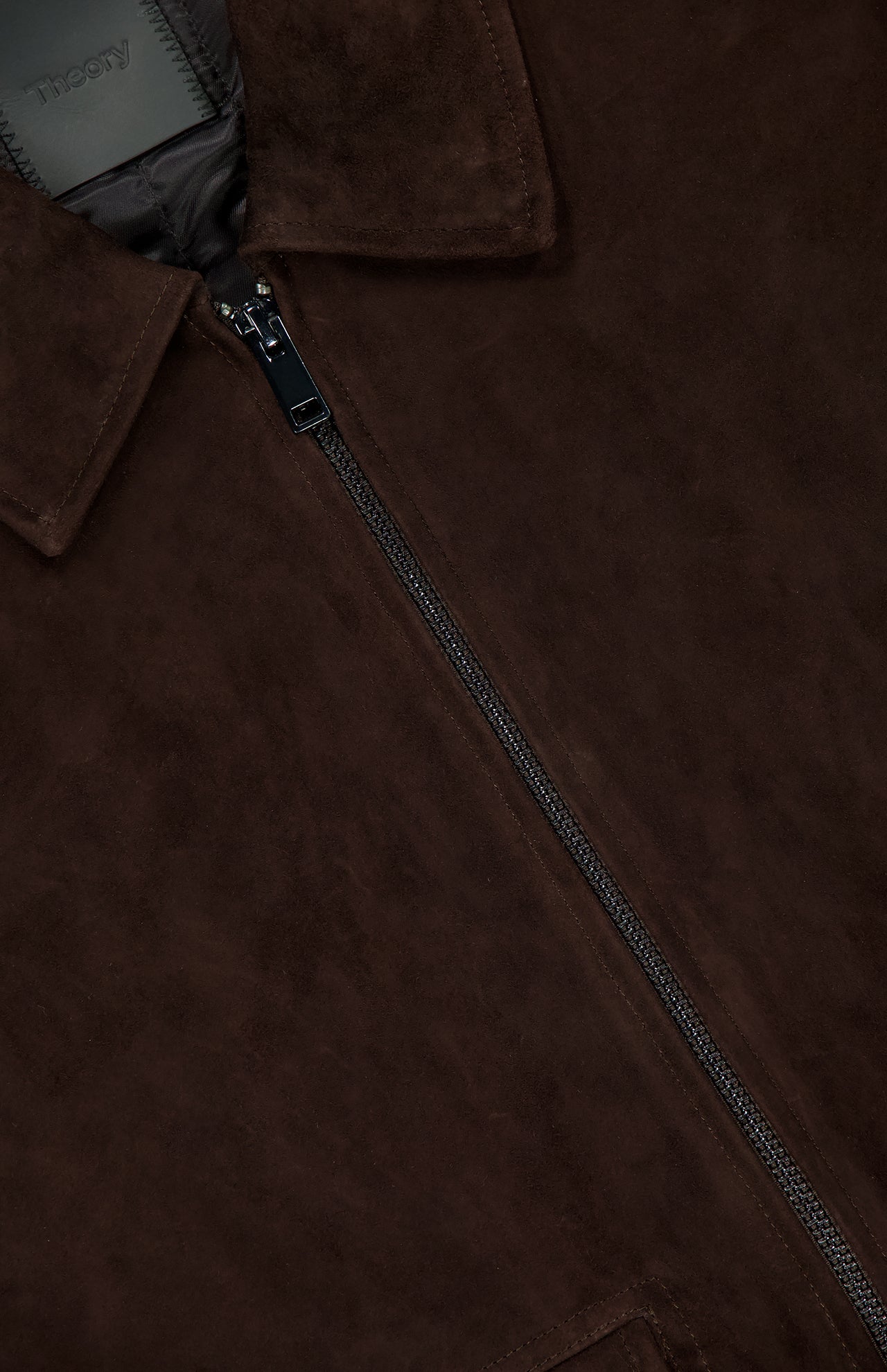Close-up of the THEORY Aviator Lamb Leather Jacket for men in dark brown, featuring a visible zipper, collar, soft leather texture, and part of the inner label.