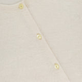 Close-up of THEORY's Brushed Cashmere Cardigan in ivory, featuring a round neckline, light buttons, and soft textured lightweight cashmere. A partially visible black brand label appears at the top left.