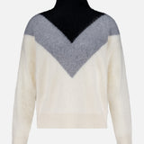 The THEORY Cashmere Chevron Yoke Sweater features a fuzzy, long-sleeve design with a high black collar, black upper chest, gray chevron V-shape midsection, and cream white sleeves and lower body.