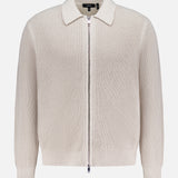 The THEORY Gary Zip Sweater Jacket features a beige waffle-knit texture, long sleeves, front zipper closure, and classic collar, shown against a plain white background.